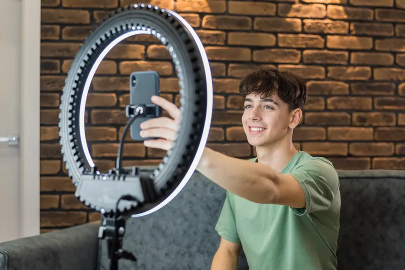 Junger Creator filmt sich mit Smartphone und Ringlicht
