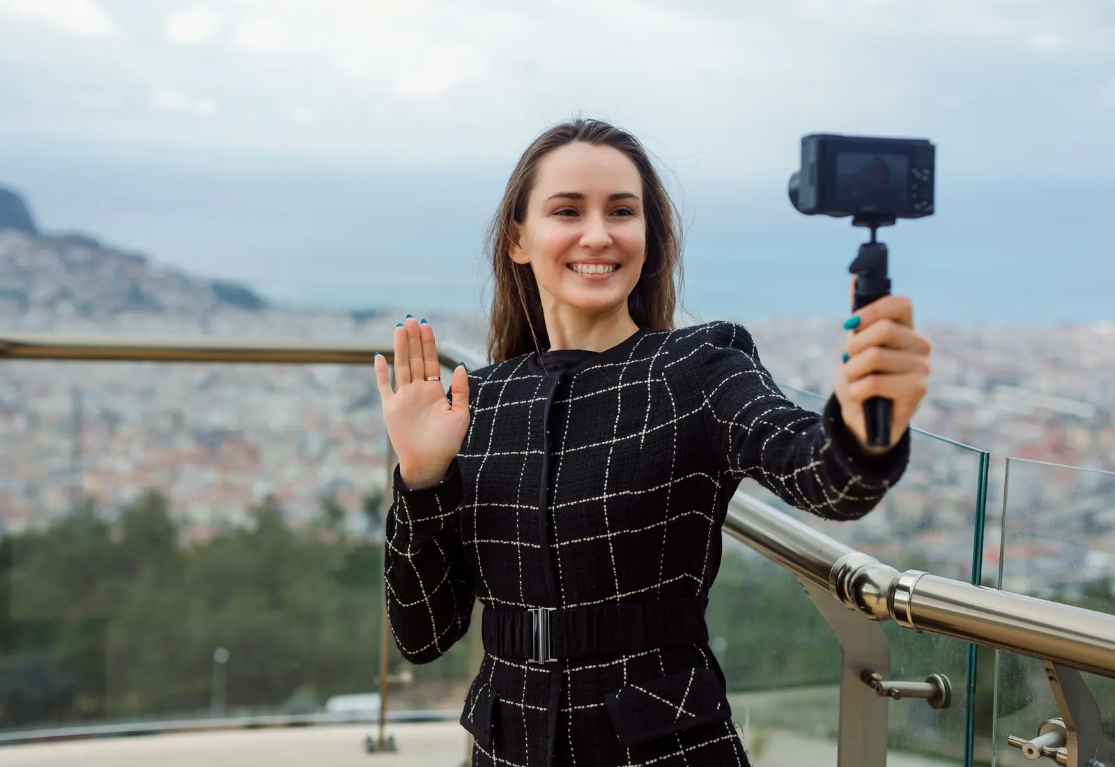 Bloggerin filmt sich mit Kamera vor einer Stadtkulisse